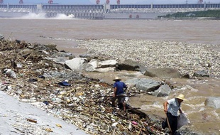Des ouvriers chinois ramassent les ordures du fleuve Yangtse face au barrage des Trois Gorges.