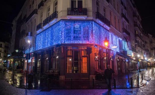 Un homme marche dans une rue vide de Bruxelles devant le bar fermé "Le roi des Belges" le 21 novembre 2015