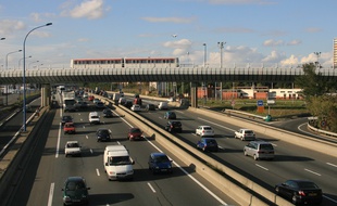 circulation automobile. metro toulousain passant sur un sur la rocade de Toulouse. avion dans un ciel bleu.