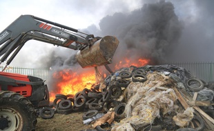 Un feu allumé par des agriculteurs devant l'usine Lactalis de Laval, le 27 juillet 2015.