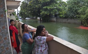 Des habitants regardent l'eau qui envahit les rues à Hyderabad (Inde), le 20 août 2020.