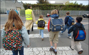 Une mère de famille accompagne des enfants qui vont à l'école.