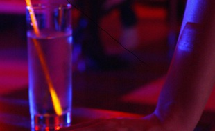 Jeune fille avec un verre d'alcool dans un bar (illustration)