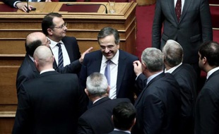 Le Premier ministre grec Antonis Samaras (c) congratulé par des députés au Parlement grec à Athènes après l'adoption du budget 2015, le 7 décembre 2014