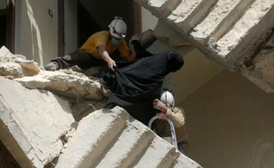 Des habitants évacués de leur immeuble après un raid aérien, à Alep le 28 avril 2016, en Syrie