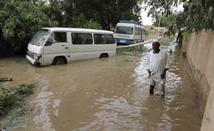 Un homme les pieds dans l'eau dans une ville au sud de Khartoum (Soudan) pendant les inondations de l'été 2020.