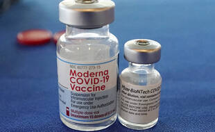 A gauche un flacon de vaccin Moderna et à droite un flacon de vaccin Pfizer.