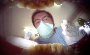 Illustration d'une consultation chez le dentiste, depuis la bouche d'un patient.