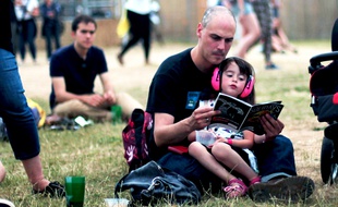 Aux Solidays 2015, un père et sa fille choisissent leur prochain concert dans le guide du festival.