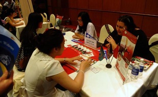 Des étudiants vietnamiens se renseignent sur un établissement américain, lors d'un salon international sur l'éducation, le 26 octobre 2014 à Hanoi