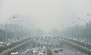 Des véhicules lors d'un jour de brouillard à Pékin, le 23 juin 2015