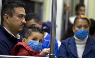 Au Mexique, les habitants se couvrent la bouche de masques alors que la grippe porcine frappe le pays.