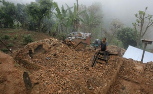 Un homme se tient sur les décombres de sa maison, à Gorkha, au Népal, le 2 mai 2015.