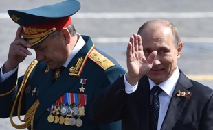 Le président russe Vladimir Poutine (d) et le ministre de la Défense Serguei Shoïgou quittent la place Rouge à Moscou après la parade militaire, le 9 mai 2015