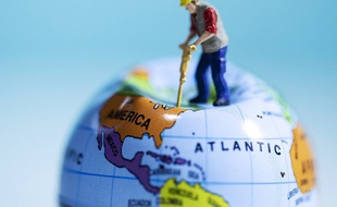 Une figurine plante un marteau piqueur dans un globe terrestre (image d'illustration).