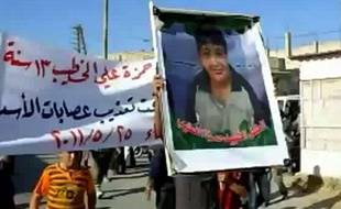 Un manifestant syrien brandit une image de Hamza al-Khatib lors de ses funérailles, près de Deraa, le 25 mai 2011.