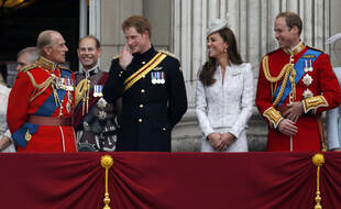 Sur cette photo datant de 2014, le prince Harry, rit avec son grand-père le prince Philip, Kate, et le prince William au balcon de Buckingham Palace.