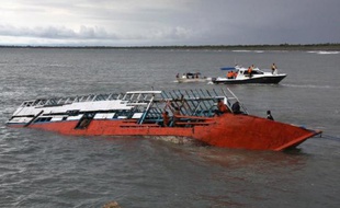 Des sauveteurs inspectent un bateau naufragé à l'Est de Java le 21 décembre 2011