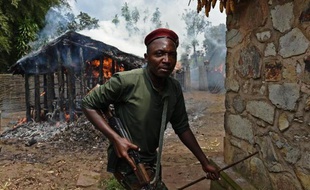 Un soldat sort d'une maison incendiée par des opposants le 5 juin 2015 à Mugongomanga, près de Bujumbura