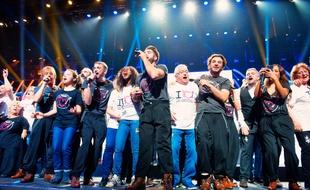 Les chanteurs avec les bénévoles, pendant le spectacle des Enfoirés, diffusé vendredi soir sur TF1.