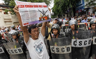 Un manifestant antichinois devant une rangée de policiers près du consulat chinois à Ho Chi Minh Ville, le 11 mai 2014.