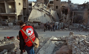 Un volontaire de la Croix Rouge franchit des gravas à Douma, dans la Ghouta orientale, le 5 mars.