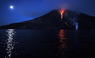 Coulée de lune sur la mer et coulée de lave sur le Stromboli, dans les îles Éoliennes en Italie, le 9 août 2014.