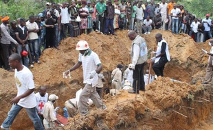Des personnels de la Croix-Rouge près d'une fosse après le massacre de 22 personnes par des rebelles ougandais, le 20 octobre 2014 à Beni, dans l'est de la RDC