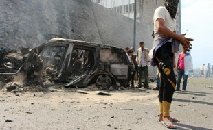 Des yéménites sur les lieux de l'attentat à la voiture piégée qui a tué le gouverneur de la province d'Aden et à au moins six gardes du corps, le 6 décembre 2015 à Aden