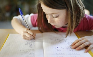 Une petite fille fait ses devoirs