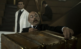 Alphonse Bertillon (Christian Hecq) examine une malle dans laquelle se trouve le corps d'une inconnue