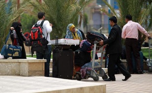 Des gens portent leurs valises à l'aéroport de Sanaa pour fuir le pays le 8 avril 2015