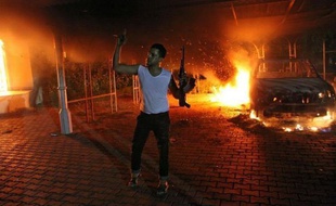 Un homme agite son arme devant le bâtiment du consulat des Etats-Unis qui vient d'être incendié à Benghazi, en Libye,au soir du 11 septembre 2012