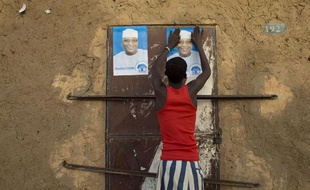 Un jeune Malien colle une affiche de campagne pour le candidat Ibrahim Boubacar Keita à Gao, au Nord du Mali, le 25 juillet 2013.