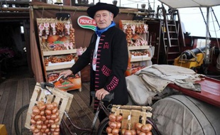 Des cageots d'oignons rosés de Roscoff s'entassent dans la cale d'un trois-mâts, réplique d'une frégate corsaire du XVIIIe siècle, dans le port de la petite cité bretonne. Destination Londres, où le légume, "so delicious", devrait ravir les palais.