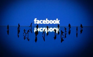 Des figurines sont posées devant le logo facebook