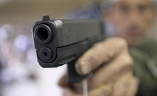Un client essaie un pistolet Glock dans une boutique d'armes à feu, en Arizona.