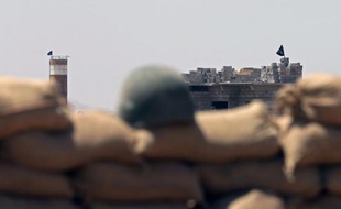 Un drapeau de l'Etat islamique (EI) flotte face à une position tenue par les Peshmerga, les soldats kurdes, le 26 juin 2014 à Sulaiman Bek, entre Bagdad et Kirkouk