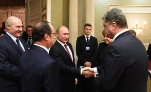 Le président russe Vladimir Poutine (c) serre la main du président ukrainien Petro Porochenko (d), le 11 février 2015 à Minsk