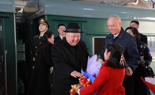 Kim Jong-un reçoit un bouquet de fleurs à son arrivée en train à Pékin, le 8 janvier 2019.