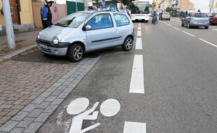 Une voiture garée en vrac sur une piste cyclable. Illustration.