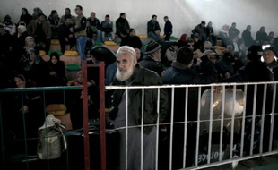 Des Palestiniens attendent la permission d'entrer en Egypte, au point de contrôle de Rafah, dans la bande de Gaza, le 13 février 2016