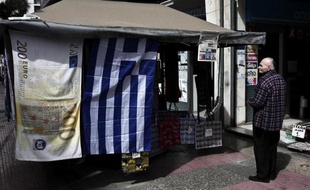 Un drapeau grec et une serviette illustrée d'un billet de 200 euros suspendus à un kiosque à Athènes le 22 mars 2015