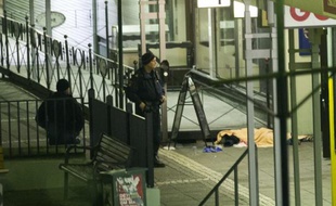 Des policiers près du corps de l'une des victimes de la fusillade commise le 18 mars 2015 devant un pub à Goteberg