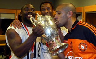 Jean-Claude Darcheville (à g.) soulevant la Coupe de France en 2002, en compagnie de Richard Martini et Seydou Keita.