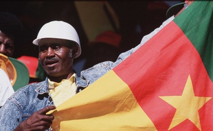 Un homme tient le drapeau du Cameroun dans ses mains