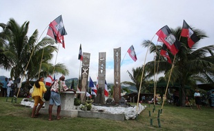 Des Polynésiens devant le mémorial rendant hommage aux victimes des tests nucléaire en 2014 à Papeete.