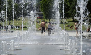 Des parisiens se rafraîchissent dans le parc André Citroen, alors que les températures grimpent, le 30 juin 2015