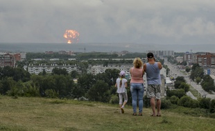 (Illustration) Une famille observe des explosions dans un dépôt de munitions militaires situé près de la ville d'Achinsk, dans la région de Krasnoïarsk, dans l'est de la Sibérie, à Achinsk, en Russie, le 5 août 2019.