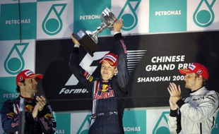 L'Allemand Sebastian Vettel, soulevant le trophée du Grand Prix de Chine, le 19 avril 2009, devant Marc Webber (à gauche ) et Jenson Button.